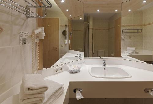 a bathroom with a sink and a large mirror at Kim Hotel Dresden in Dresden