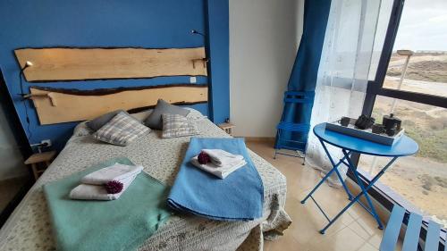 - une chambre avec un lit avec deux oreillers et une table dans l'établissement Los Abrigos Ocean relax, wifi, playas, à Los Abrigos