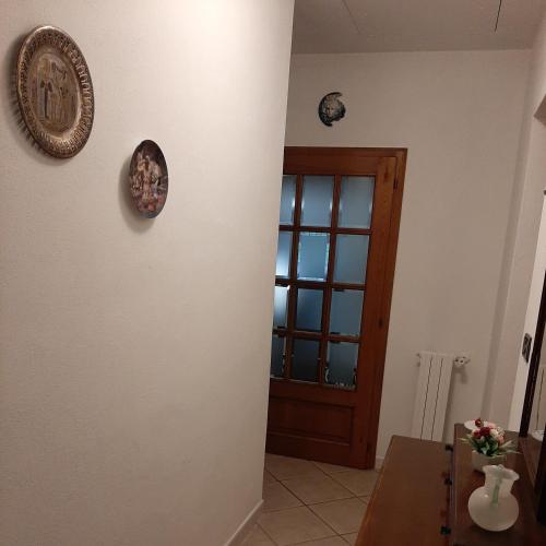 a room with a door and a table and a clock at Casa Zeno in Volterra