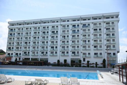un hotel con piscina frente a un edificio en Apartman Zara en Jagodina