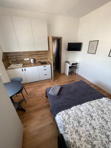 Airport Apartment 29 Self Check-In Free parking في فيلنيوس: غرفة نوم مع سرير ومطبخ مع مكتب