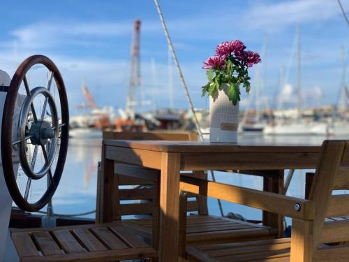 a wooden table with a vase of flowers on it at Sailing Nights Boat&breakfast in Alghero