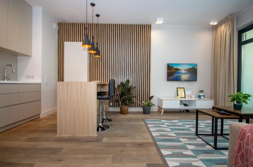 a living room with a kitchen and a dining room at InPoint Central Apartments in Kraków