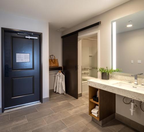 a bathroom with two sinks and a blue door at Ayres Hotel Rialto Fontana in Rialto