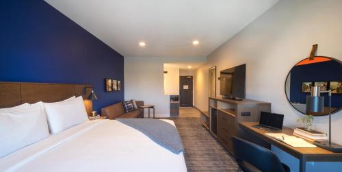 ein Hotelzimmer mit einem Bett und einem Schreibtisch mit einem Laptop in der Unterkunft Ayres Hotel Rialto Fontana in Rialto
