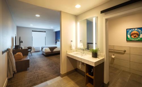 a bathroom with a sink and a room with a bed at Ayres Hotel Rialto Fontana in Rialto