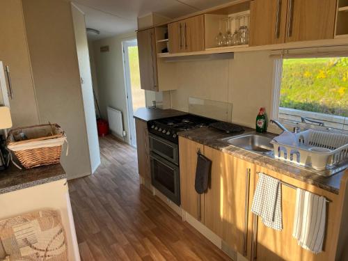 a kitchen with a sink and a stove top oven at Forget-me-not Holidays in Annalong