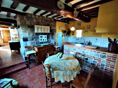 a kitchen with a table and a stone wall at La Roselière in Sainte-Colombe