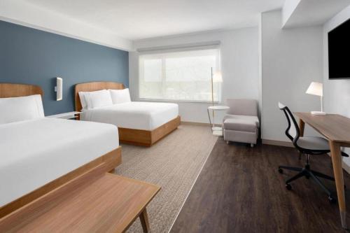 a hotel room with two beds and a desk at Element Tampa Midtown in Tampa
