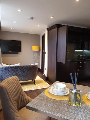 a living room with a table and a couch at The Queens Head, Parkside Apartment 4 in Burley in Wharfedale