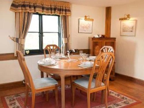 a dining room with a wooden table and chairs at Paddock Barn ~ Short & Long term stay, pets welcome ~ Woodbridge, Framlingham ar in Cretingham