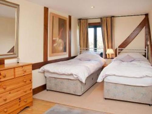 a bedroom with two twin beds and a dresser at Paddock Barn ~ Short & Long term stay, pets welcome ~ Woodbridge, Framlingham ar in Cretingham