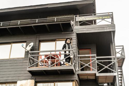 a woman standing on a balcony of a building at Montaña Blanca in Farellones