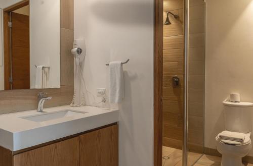 a bathroom with a sink and a toilet at Tú Paraiso Privado- Lahun Suites Playa del carmen in Playa del Carmen