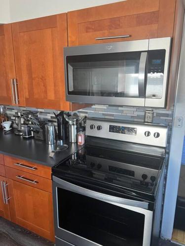 a kitchen with a stove and a microwave at Cute home near EMU and U of M in Ypsilanti