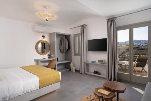 カルテラドスにあるSanta Mar ECO Suitesのベッドルーム(ベッド1台、テレビ、テーブル付)