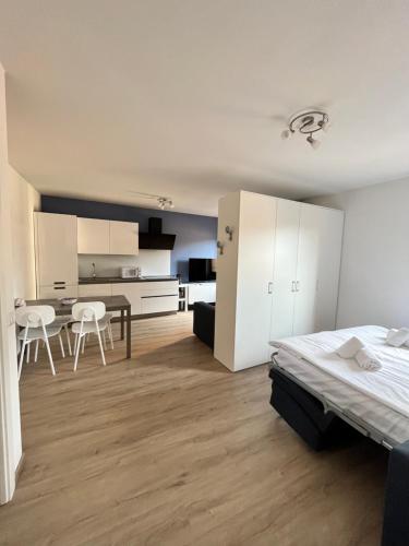 a bedroom with a bed and a table and a kitchen at Casa Margheritina in Malcesine
