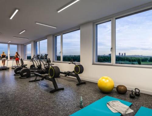 um ginásio com equipamento de exercício e grandes janelas em Donaublick Oasis: Stylische Wohnung em Viena