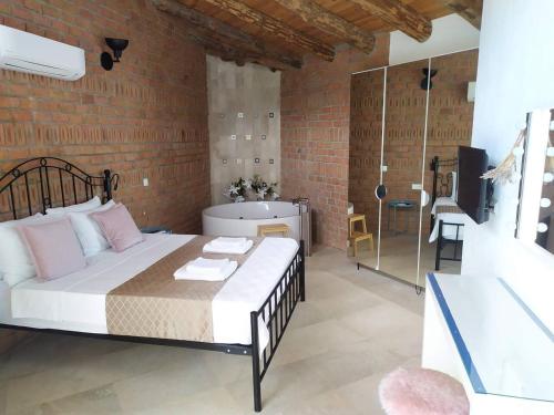 a bedroom with a large bed and a brick wall at Villa Alaçatı (İslamlar-Kalkan) in Kaş