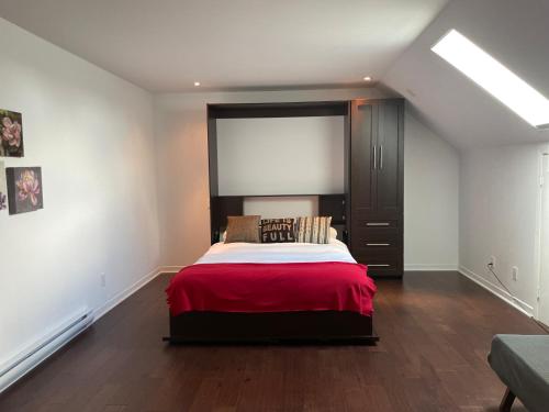 1 dormitorio con 1 cama con manta roja en Condos Vacances Orford Suite 1 chambre en Orford