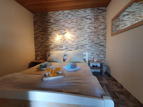 1 dormitorio con 1 cama grande y pared de ladrillo en Apartmani Daria & Jure en Trogir