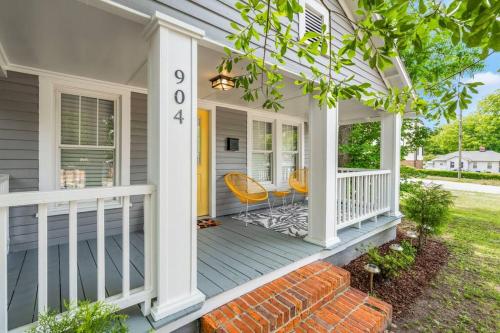 a front porch of a house with orange chairs at Bright + New - Fire Pit - Hammock - 3 bd in Raleigh