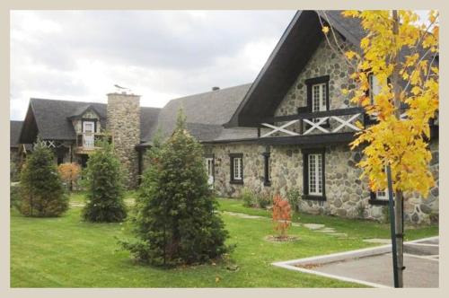 a large stone house with trees in front of it at Condos Vacances Orford Suite 1 chambre in Orford