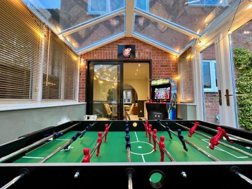 a ping pong table in a house with a game room at 4-bed Cotswold getaway with hot tub & gaming room in Churchdown