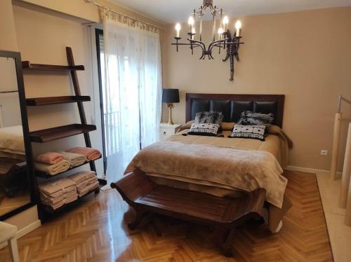 sypialnia z dużym łóżkiem i żyrandolem w obiekcie Apartamento plaza Mayor / Húmedo w mieście León