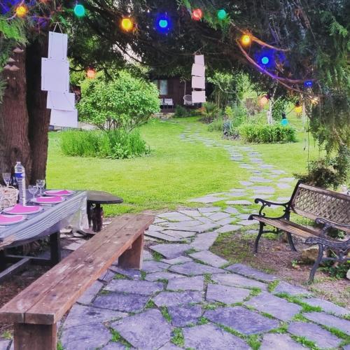 a picnic table and bench in a garden with lights at Les Glycines de Monchy- Chambres d'hôtes in Monchy-Humières