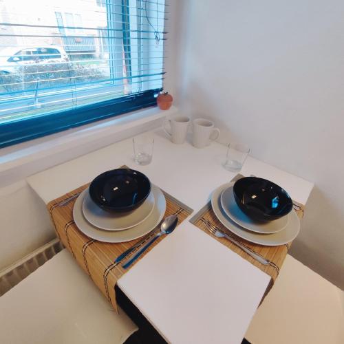 a table with two plates and glasses and a window at Functional studio/room Copenhagen in Copenhagen
