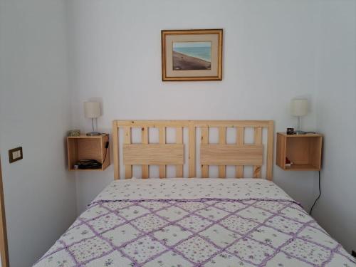 a bedroom with a bed and a picture on the wall at La casa delle sirene sul mare di Anzio in Anzio