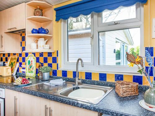 a kitchen with a sink and a window at Skylarks in St Merryn