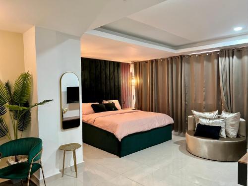 1 dormitorio con 1 cama extragrande y 1 silla en The Fjord at Libi Apartment en Accra