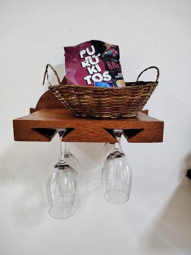 a basket and two wine glasses on a shelf at Recanto Serra do Trovão in Ouro Preto