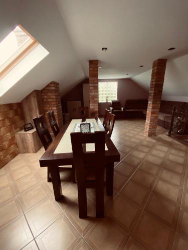 a dining room with a table and chairs and a couch at Agroturystyka ‚U Misia’ in Krzywopłoty