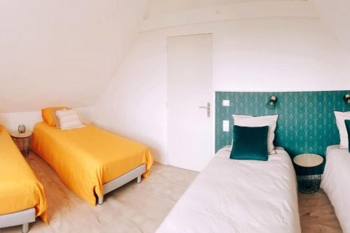 2 camas en una habitación de color amarillo y verde en Villa Mon Rêve 12 pers à 500m de la plage, en Bréhal