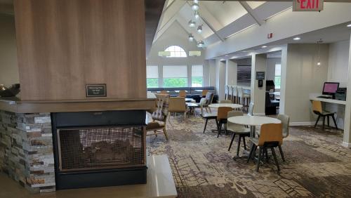 eine Lobby mit einem Kamin sowie Tischen und Stühlen in der Unterkunft Residence Inn Kansas City Independence in Independence