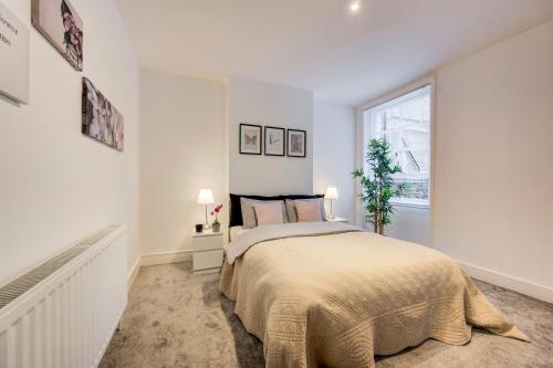 a white bedroom with a bed and a window at Beautuful 2 bed apartment in central London in London