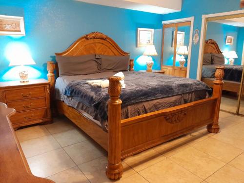 1 dormitorio con cama de madera y espejo en Susan and Ledif's Tropical Hideaway en Greenacres City