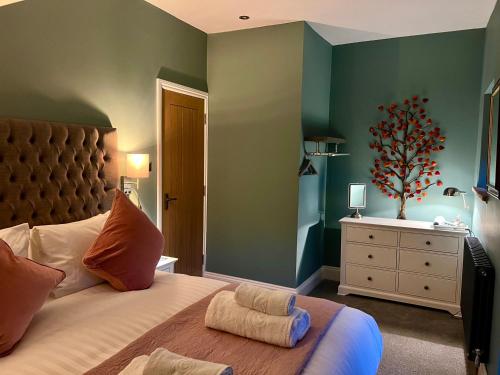 a bedroom with a large bed with green walls at High Street Apartment in Windermere