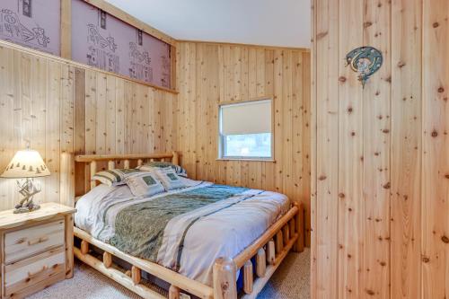 ein Schlafzimmer mit einem Bett in einer Holzwand in der Unterkunft Harrison Cabin with Fire Pit and Elbow Lake Access! in Harrison