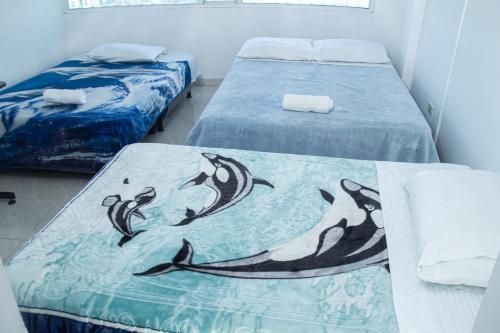 een kamer met twee bedden met dolfijnen erop bij Hotel El Palacio Del Rey in Duitama