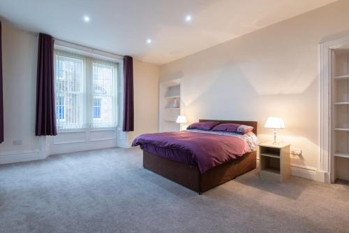 a bedroom with a bed and a large window at CASTLEBANK HOUSE FLATS, DINGWALL in Dingwall