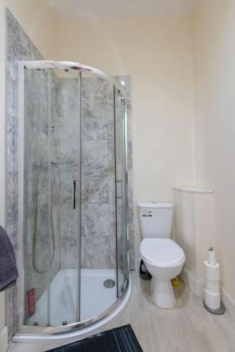 a bathroom with a shower and a toilet at CASTLEBANK HOUSE FLATS, DINGWALL in Dingwall