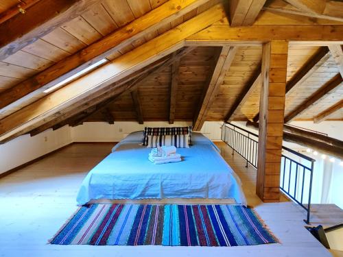 a large attic room with a blue bed in it at Habezeiko - The Vintage House in Afitos