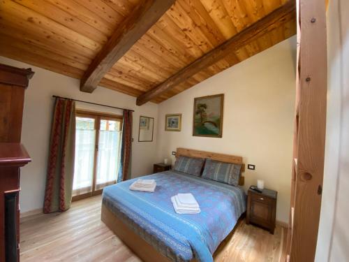 a bedroom with a bed and a wooden ceiling at L'Oasi di Sodani 2 in Sampeyre