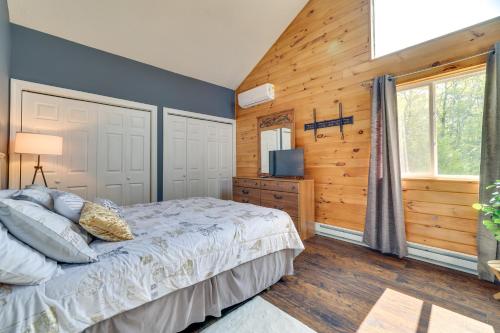 a bedroom with a bed and a wooden wall at Exciting Tobyhanna Home Near Kalahari Water Park! in Tobyhanna