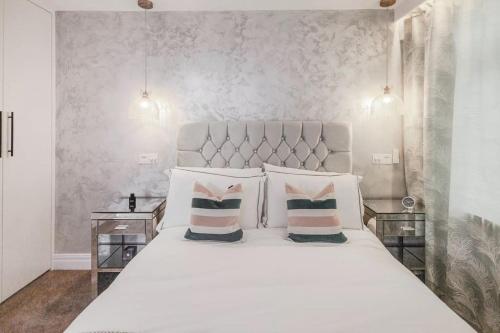 ein Schlafzimmer mit einem großen weißen Bett mit zwei Kissen in der Unterkunft Queens Apartment ( Entire 2 bed apartment ) in Potters Bar