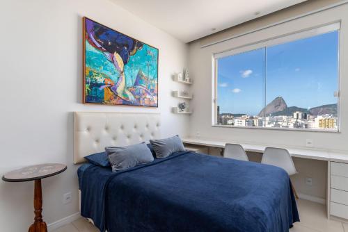 1 dormitorio con cama azul y ventana grande en Studio Catete, en Río de Janeiro